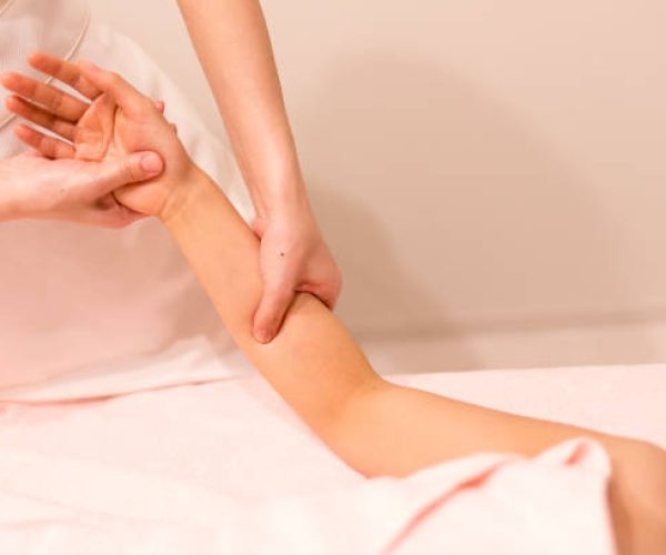 woman receiving oil massage on arm